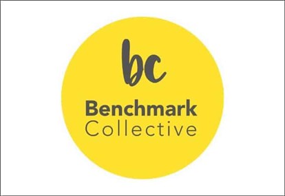 Benchmark Collective logo in dark grey lettering on a yellow circle background